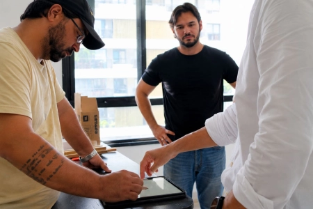 Equipe técnica revisa solução estrutural de bancada suspensa durante execução do projeto